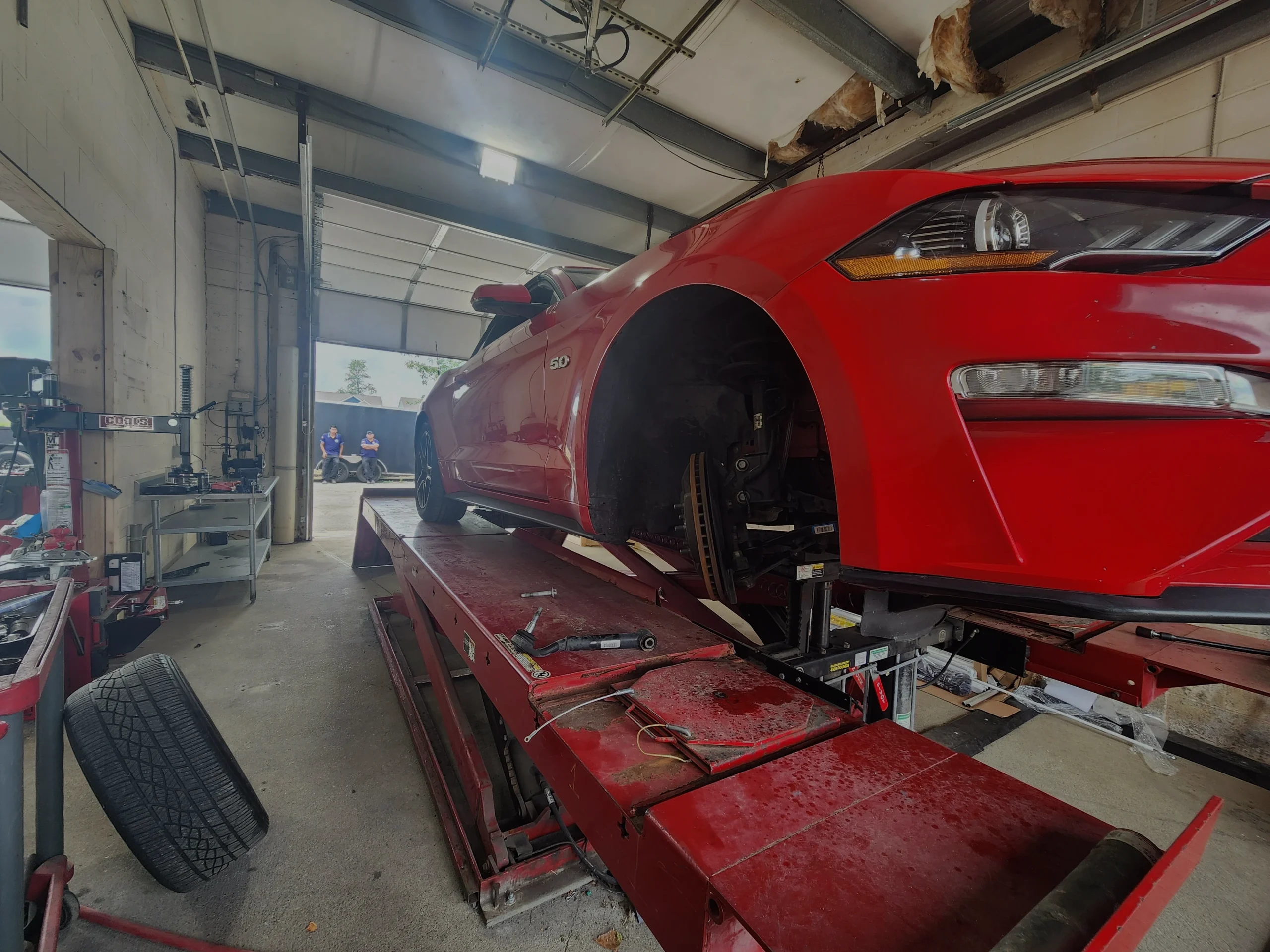 Technician performing a front brake repair on a customer vehicle at Supreme Tires in Floyds Knobs, Indiana.